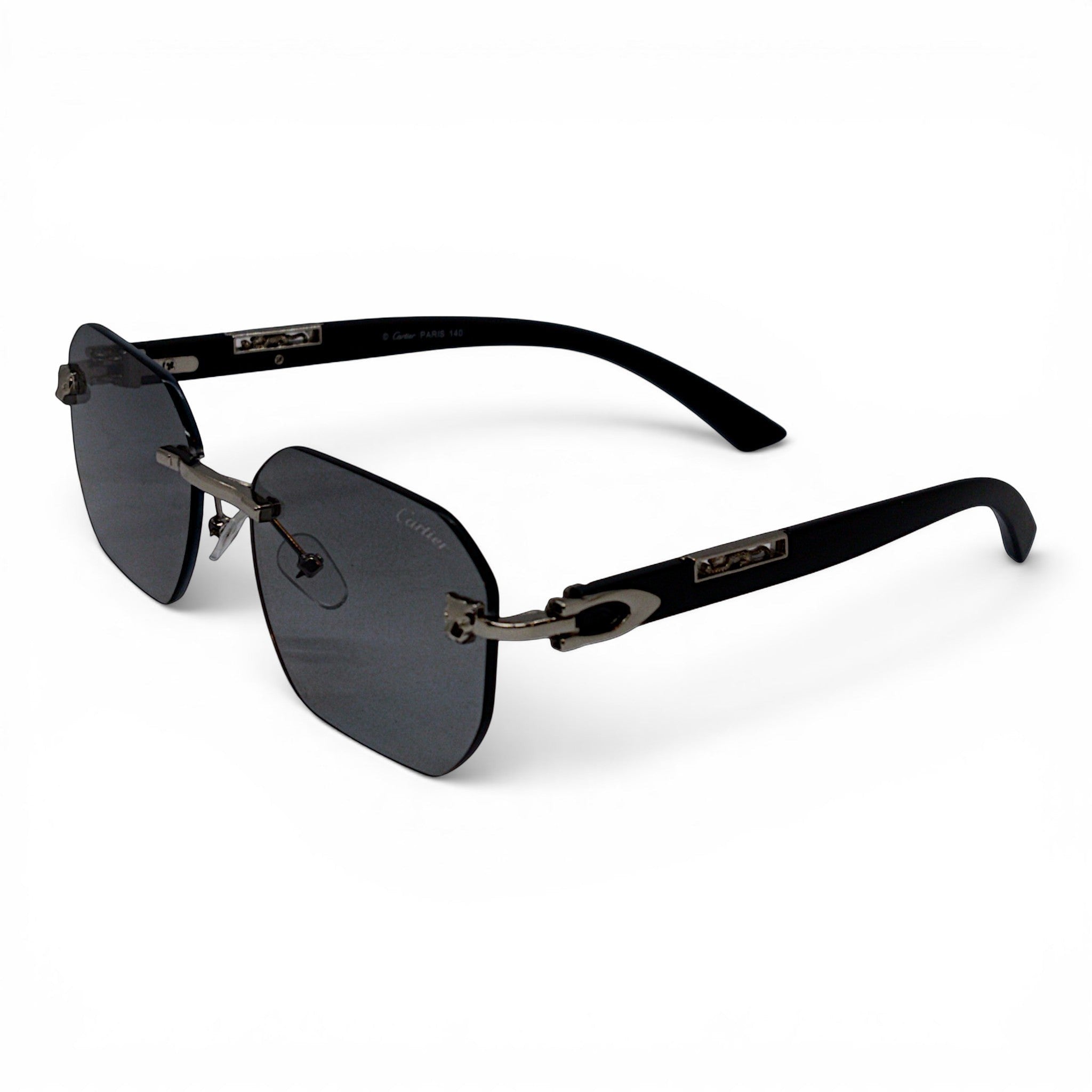 nadaraty eyewear Photocromic ctr 01 rimless sunglasses with dark grey lenses and black arms featuring silver C detail.